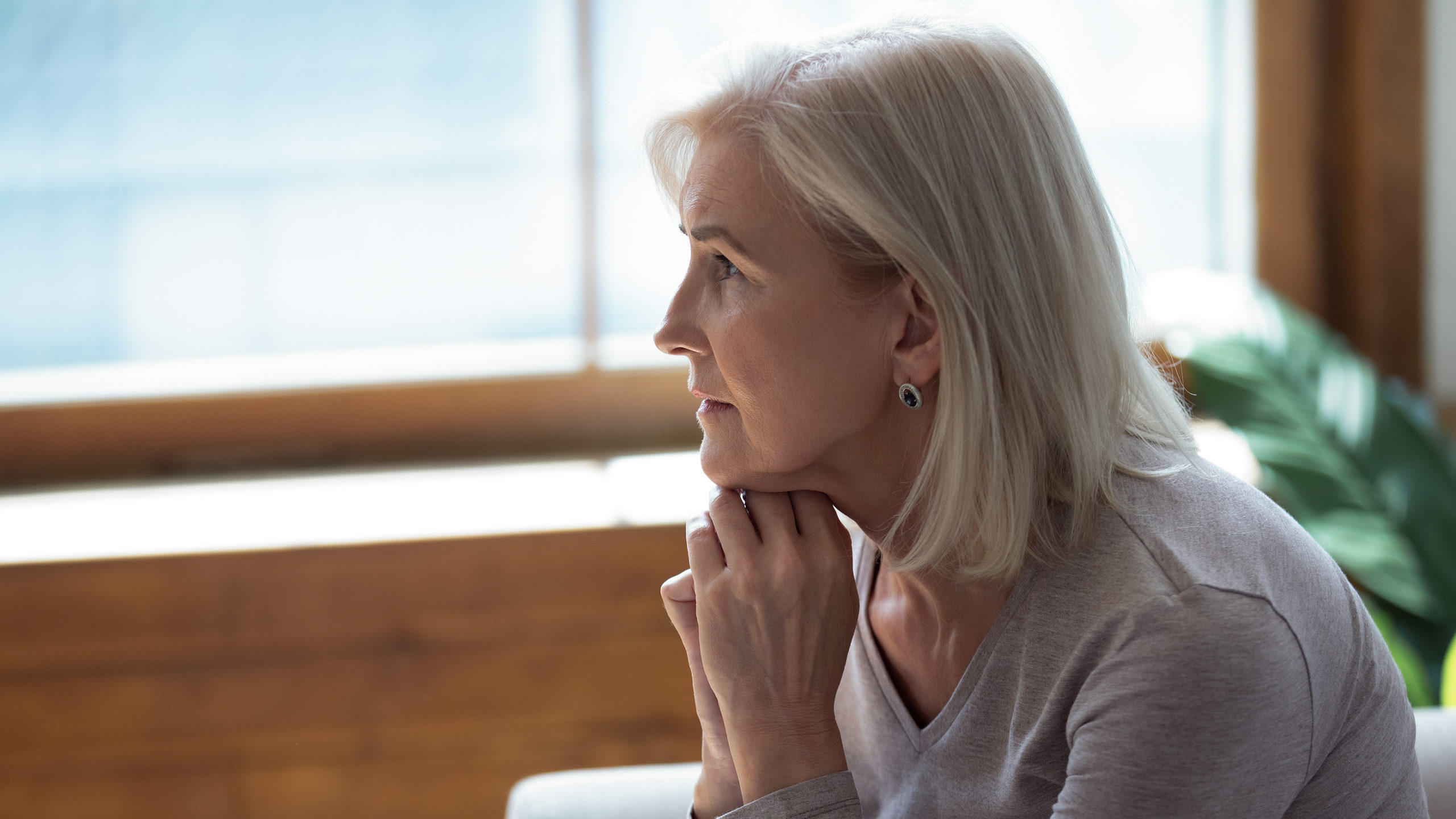 Unhappy lonely older woman sitting alone and thinking about problems